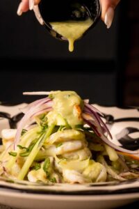 Mariposas Aguachiles Verdes: butterflied shrimp, red onion, cucumber, aceite de chile, avocado.