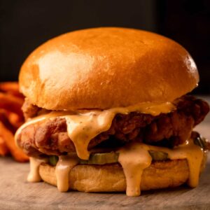 Mariposas Chicken Sandwich: breaded chicken thigh, secret sauce, dill pickles, toasted brioche buns.