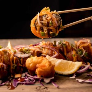 Mariposas Dragon Roll: Fried California roll, jalapeño crab, meat, onion, cream cheese, spicy mayo, Terikayi shrimp, tempura, sesame seeds.