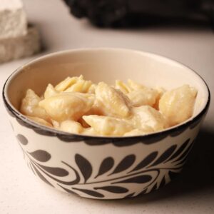 Mariposas kids mac and cheese with creamy white cheddar sauce and shell pasta in a patterned bowl.
